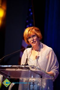 President, JoAnna Schilling speaking on stage.