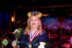 Woman wearing black and gold Mickey Mouse ears.