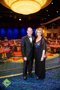 Howard Kummerman standing with a woman in a black dress.