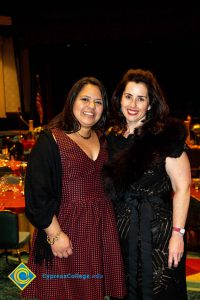 Two women with dark hair smiling.