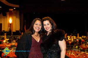 Two women with dark hair smiling.