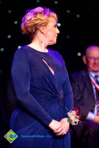 Woman wearing a blue dress looking to the side.