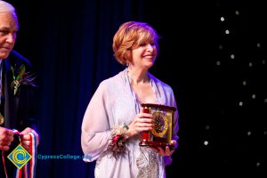 Dr. JoAnna Schilling smiling and holding an award.