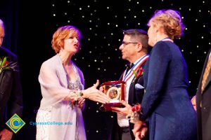 Dr. JoAnna Schilling extending her hand to shake hands with a woman in a blue dress.