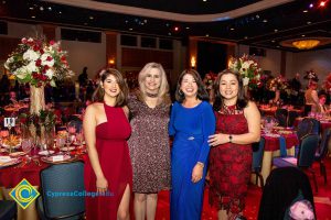 Four women in dresses smiling