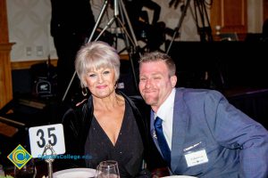 Woman with short grey hair and a man in a blue suit and tie.