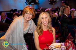 President, JoAnna Schilling with a blond woman in a red dress.