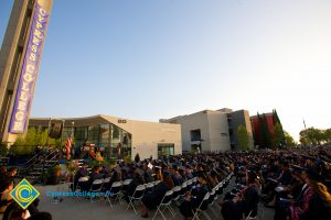 View of commencement ceremony with campanile in the background.