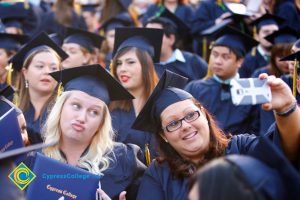 Graduates taking selfies during commencement.