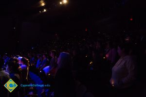 The audience holds lights at Yom HaShoah