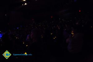The audience holds lights at Yom HaShoah