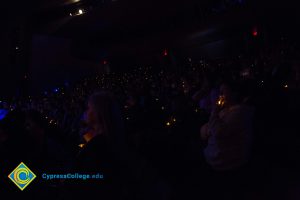 The audience holds lights at Yom HaShoah