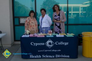 Staff members of the Health Science Division standing at table with informative flyers