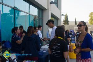 Students and staff gathered at table in front of Student Center