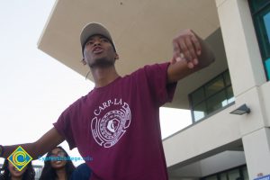 Male student wearing CARP LA shirt with his arms out