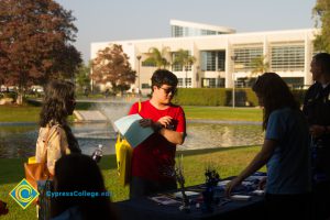 Students gathered at table near the pond