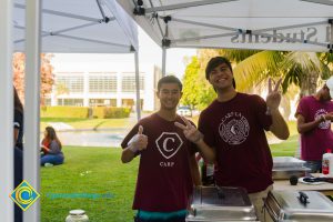 Students wearing maroon shirts and holding up peace signs