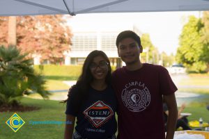 Male student wearing maroon CARP LA t-shirt with arm around female student wearing (STEM)2 t-shirt