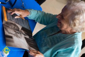 Female Holocaust survivor signing Yom HaShoah program