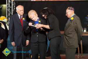 Holocaust survivors lighting a candle on stage