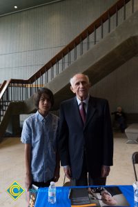 Male Holocaust survivor standing next to young man