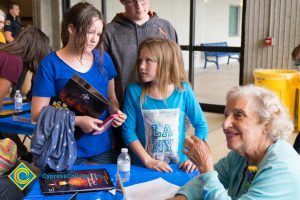 Female Holocaust survivor at table with two young girls