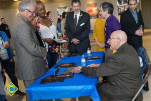 Dr. Bob Simpson, student, Cliff Lester, David Halahmy look on while Holocausst Survivor signs program