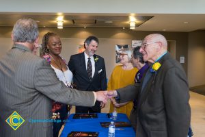 Bob Simpson shaking hands with Holocaust survivor