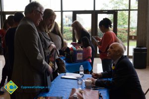 Then-president Bob Simpson and his wife talking with male Holocaust survivor