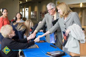 Then-president Bob Simpson and his wife shaking hands with female Holocaust survivor