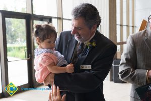 Professor Emeritus Cliff Lester holding a baby girl