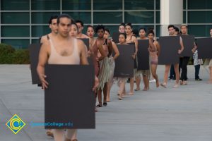 Dancers, carrying signs, walking to perform