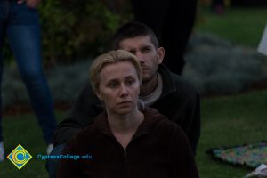 Man sitting behind woman at Yom HaShoah event