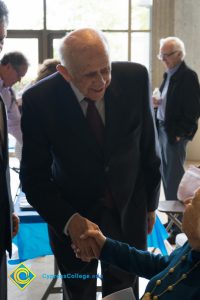 Male Holocaust survivor shaking hands with female Holocaust survivor in wheelchair