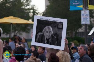 Dancer holding up sign of Holocaust survivor Marthe Cohn