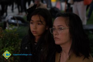Woman and young girl watching Yom HaShoah event