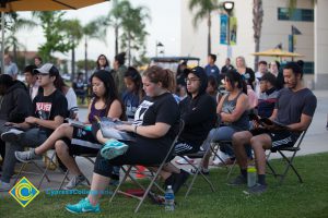 Attendees looking at their programs at Yom HaShoah event