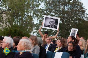 Dancers among audience, holding up images of Holocaust survivors