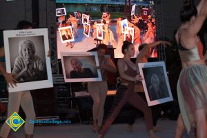 Dancers holding up photographs of Holocaust survivors