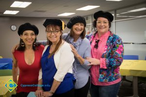 Faculty pose in graduation caps