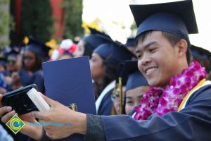Students pose for selfies at commencement