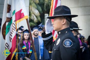 A Cypress Police officer salutes in dress uniform at commencement.