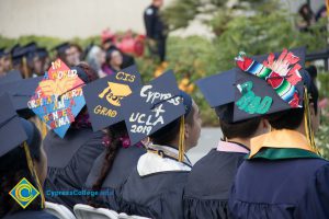 Students wearing decorated graduation caps at commencement