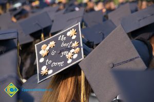 A graduation cap reads "The best is yet to come" at commencement
