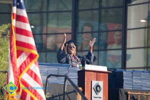 Student in regalia speaks onstage at commencement