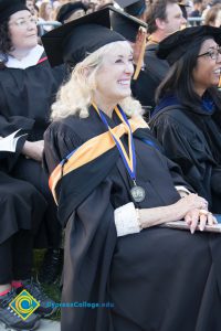 Student in regalia watches commencement