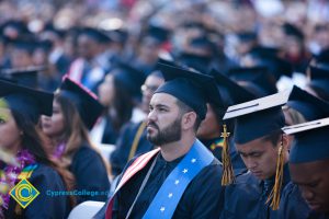 Student in regalia watches commencement