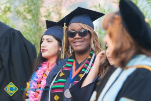 Graduates sit and smile at commencement