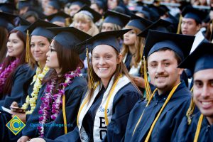 Students in graduation regalia sit in audience at commencement