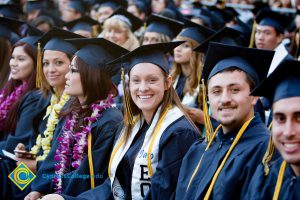 Students in graduation regalia sit in audience at commencement